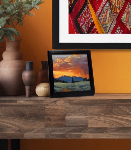 Rainy Sunset in the Tetons shown framed on a mantel against a warm orange wall